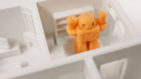 optimized orange 3D printed robot in white house