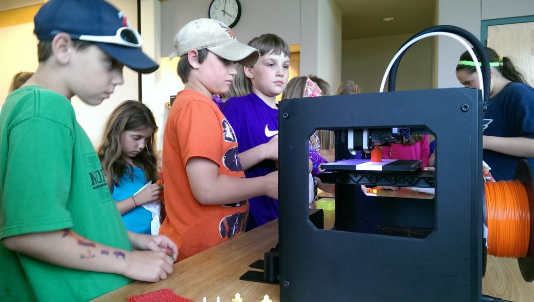 kids looking at 3d printer